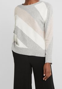 Maglione leggero a maglia con un motivo diagonale grigio, bianco e beige. Presenta un collo e polsini a costine, vestibilità comoda.