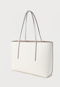 Λευκή τσάντα tote με μακριά χερούλια, λεία υφή, μινιμαλιστικό σχέδιο και αντίθετη σκοτεινή επένδυση κατά μήκος των άκρων. Ιδανική για καθημερινή χρήση.
