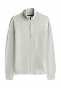 Suéter gris claro con cremallera, cuello alto, puños y dobladillo acanalados. Cuenta con un pequeño logo en el pecho. Textura suave de punto.