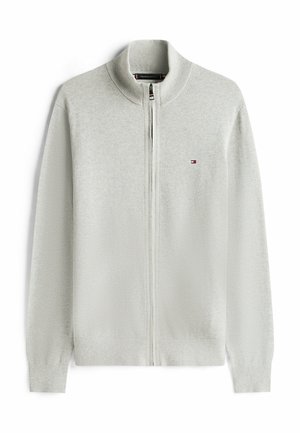 Lichtgrijze trui met rits en hoge kraag, geribbelde manchetten en zoom. Voorzien van een klein logo op de borst. Zachte, gebreide textuur.