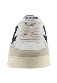 Sneaker bianca in pelle con accenti in suede beige, strisce laterali in blu navy e lacci testurizzati. Presenta perforazioni per la traspirabilità. Suola in gomma.