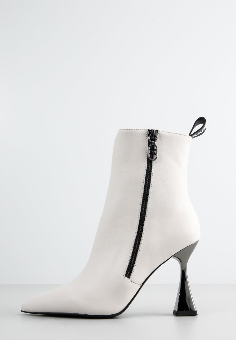 Weiße Knöchelstiefel aus glattem Leder, mit einem schwarzen Reißverschluss, spitzer Zehenpartie und einem glanzvollen, geometrischen Absatzdesign.