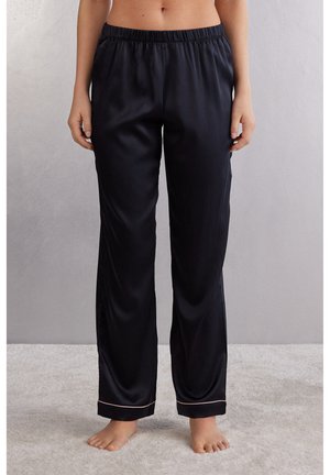 Svart satin pyjamasbyxor med elastisk midja, vida ben och en subtil ljusfärgad kant vid fållarna. Mjuk, slät textur.