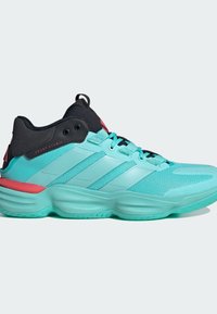 Zapatilla deportiva turquesa con tejido de malla texturizado, acentos negros y detalles en rosa. Cuenta con una suela acolchada y un talón reforzado.