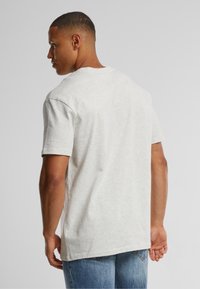Gray short-sleeve t-shirt made from soft fabric, featuring a round neckline and a relaxed fit. Visible stitching on the shoulders.