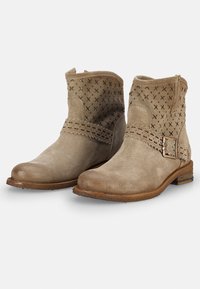 Botas de tobillo de ante topo con un upper texturizado, una correa decorativa y hebilla, y un tacón bajo y apilado. Presentan detalles recortados.
