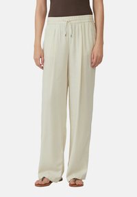 Lange broek in lichtgewicht, crème kleurige stof. Voorzien van een elastische tailleband met een trekkoord en een relaxte pasvorm. Gladde textuur.