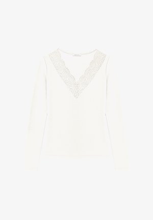 White long-sleeve top with a V-neck featuring delicate lace detailing along the neckline. Made from soft fabric with a smooth texture.