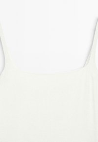Weißes Tanktop mit dünnen Trägern, aus einem weichen, strukturierten Stoff und mit einem runden Ausschnitt. Einfaches und minimalistisches Design.