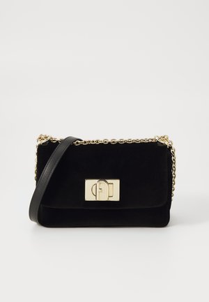 Black velvet crossbody bag with gold chain strap, rectangular shape, and a gold hardware lock detail on the front flap.