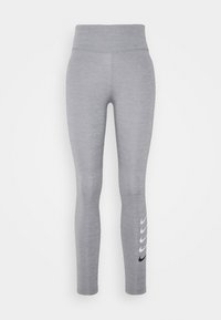Szare legginsy sportowe z wysokim stanem, wykonane z teksturowanego materiału. Posiadają czarne logo Nike w falistym wzorze wzdłuż dolnej części nogawki.