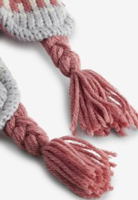 Stickad tyg med en grå och rosa färgkombination, prytt med flätade rosa tofsar i ändarna, som framhäver en mjuk textur och detaljerade mönster.