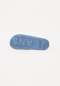 Világoskék gumitalp, amely texturált tapadási mintázattal rendelkezik, a kiemelkedő "JEANS" márkanevével.
