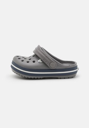 Grå slip-on træsko med justerbar hælrem, ventilationshuller og navy og hvid stribet sål.