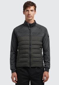 Padded jacket with a zip-front in dark gray and black. Features a smooth upper section and quilted lower section. Ribbed cuffs included.