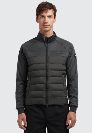 Wattierte Jacke mit einem Reißverschluss vorne in Dunkelgrau und Schwarz. Mit einem glatten oberen Bereich und einem gesteppten unteren Bereich. Rippenbündchen sind ebenfalls enthalten.