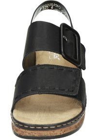 Svart sandal med en bred rem, justerbart spänne och korksula. Har en mjuk läderöverdel och en mjuk fotbädd för komfort.