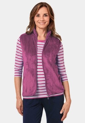 Fleece vest in paars met een hoge kraag en ritssluiting, gecombineerd met een wit en roze gestreept shirt. Gladde textuur, casual ontwerp.
