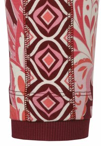 Tissu multicolore avec des motifs floraux et en losange en rose, rouge et crème ; ourlet inférieur côtelé ; coutures visibles avec une surpiqûre contrastée.