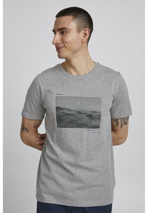 Grå bomulds T-shirt med et rektangulært monokromt grafisk landskab, ledsaget af tekst i sort, korte ærmer og rund hals.