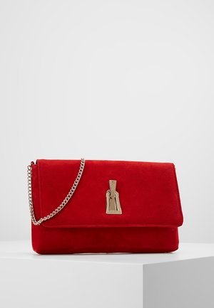 Red suede clutch bag with gold-tone chain strap and decorative gold clasp, placed on white surface against light grey background.