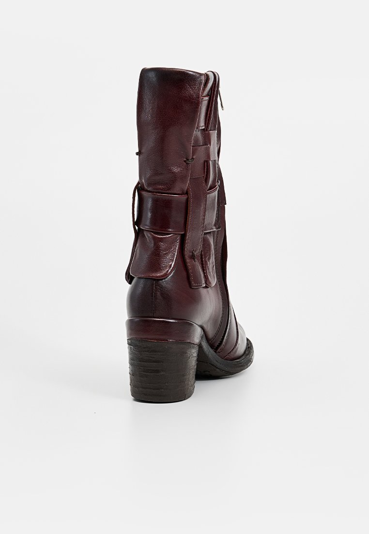 Stivaletto in pelle marrone scuro con punta tonda, lacci laterali e tacco basso impilato. La pelle ha una finitura liscia e una texture minimale.