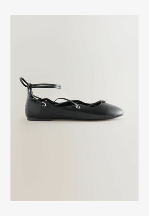 Pantof balerină plat din piele neagră, cu curea la gleznă și șireturi încrucișate, vârf ascuțit și talpă netedă, prezentat în vedere laterală pe un fundal deschis.