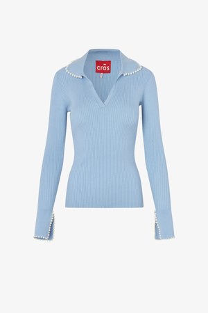 Pulover albastru deschis cu mâneci lungi, cu dungi, decolteu în V, margine cu perle la guler și la manșete, și etichetă roșie cu brandul "crās" în interiorul gulerului.