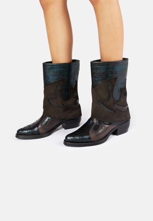Bottines en suède marron et cuir embossé crocodile bleu canard, avec des pointes effilées et des coutures décoratives ; talons bas et empilés.
