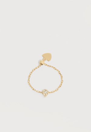 Delikāts zelta ķēdes gredzens ar asaras formas caurspīdīgu dārgu akmeni un nelielu sirds formas piekariņu, kas pievienots aizdares sprādzei.