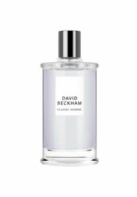 Kirkas lasinen hajuvesipullo, jossa on uurrettu pinta, hopeinen korkki ja valkoinen etiketti, jossa on musta teksti "DAVID BECKHAM CLASSIC HOMME."