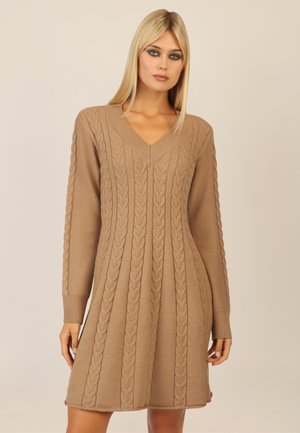 Strickkleid in hellbraun mit V-Ausschnitt, langen Ärmeln und Zopfstrickmuster. Mit lockerer Passform und gerippten Bündchen.