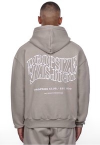 Lys grå hættetrøje med snore i hætten, prydet med hvid tekst på ryggen: "DROPSIZE" og "DROPSIZE CLUB / EST. 2020." Blød tekstur.