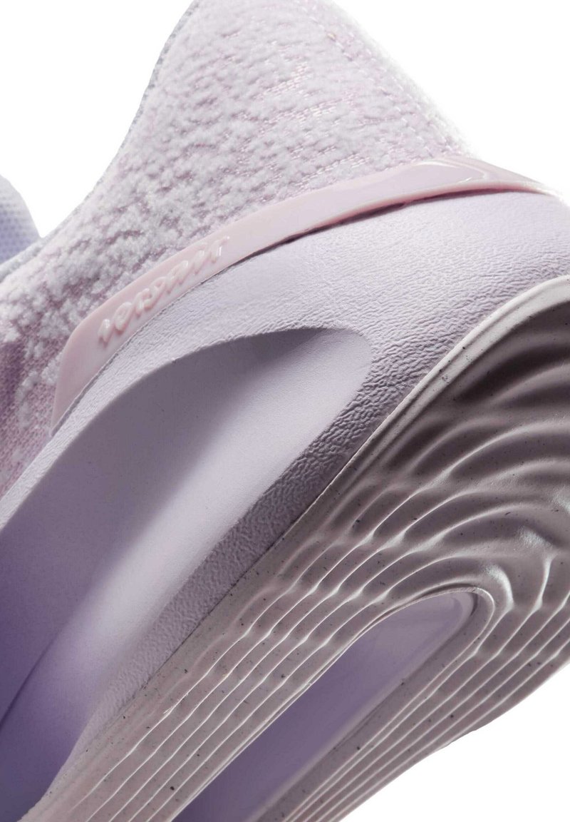 Sneaker viola chiaro con tomaia in tessuto testurizzato, tallone liscio e supportivo, e suola in gomma con scanalature. Presenta il marchio sul lato.