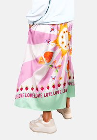 Langer, fließender Rock in Pink und Mintgrün, mit verspielten Grafiken von Sonne, Schmetterlingen, Herzen und wiederholt aufgenähtem "LOVE"-Text am Saum.