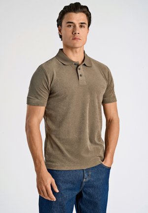Khaki polo shirt met een zachte textuur, drie knopen kraag en korte mouwen. Draagt goed met donkerblauwe spijkerbroek. Eenvoudig, casual ontwerp.