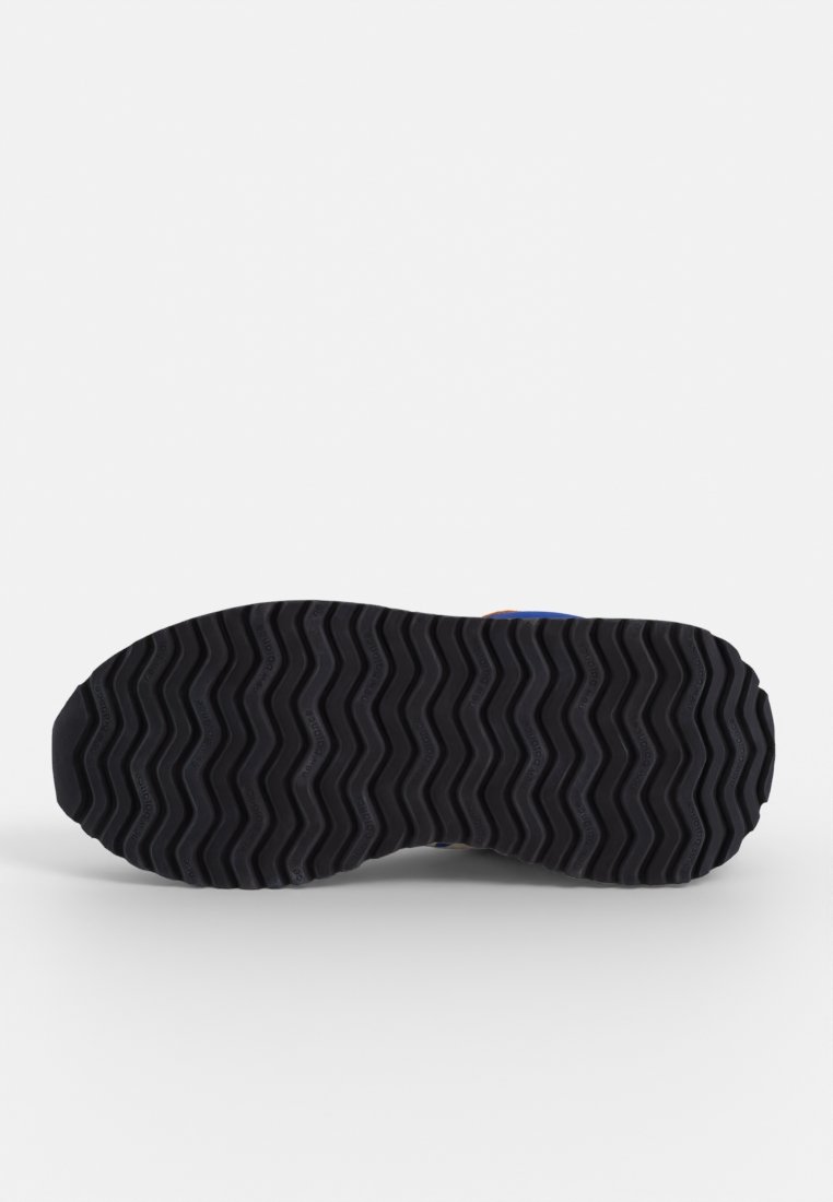Zwarte rubberen schoenzool met golfpatroon, voorzien van verhoogde texturen en groeven voor grip, ontworpen voor buitengebruik.