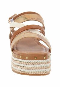 Sandales à plateforme marron et crème avec des lanières croisées, un dessus texturé, et une semelle en paille tissée ornée d'accents dorés.