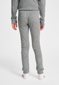 Szare, lekkie legginsy przylegają do ciała, wykonane z miękkiego, teksturowanego materiału, z gładkim pasem w talii i żebrowanymi mankietami na kostkach.
