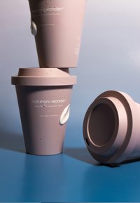 Różowy plastikowy pojemnik z teksturowaną pokrywką, z etykietą mówiącą "haruharu wonder Black Rice 10 Hyaluronic Cream" oraz kroplą kremu.