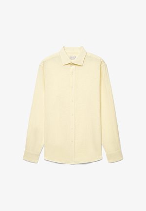 Camicia a maniche lunghe, giallo pallido, con bottoni, colletto classico e polsini abbottonati, mostrata distesa su uno sfondo bianco.