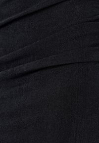 Czarny elastyczny materiał o fakturze prążkowanej, z ukośnymi fałdami i gładkim wyglądem. Odpowiedni do dopasowanego ubrania.