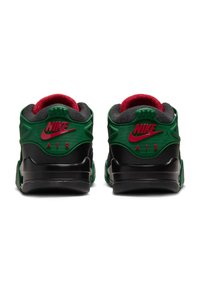 Nike-Schuhe mit einem grünen strukturierten Obermaterial, schwarzer Sohle und roten Akzenten. Mit prominentem Nike-Logo und gepolstertem Kragen für zusätzlichen Komfort.