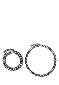 Bracciale e collana in catena di metallo nero, caratterizzati da anelli interconnessi. Il bracciale è più piccolo e dotato di chiusura, mentre la collana è più grande e regolabile.