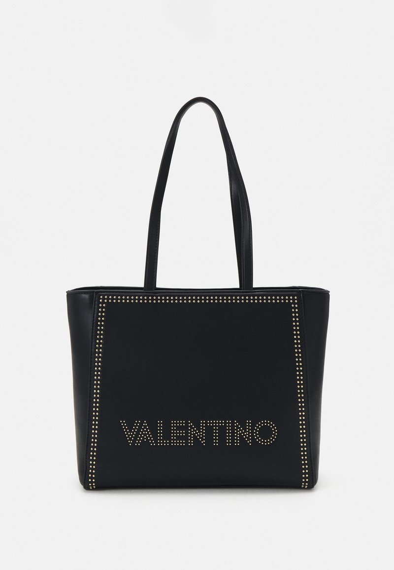 Black leather tote bag featuring gold studded accents, rectangular shape, and two handles. "VALENTINO" logo in gold studs on the front.