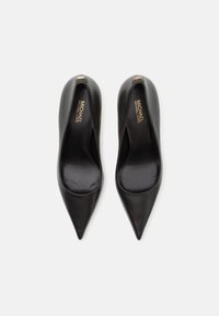 Escarpins noirs en cuir à bout pointu avec une texture lisse et un design à dos ouvert. Présente un logo en or sur la semelle intérieure.