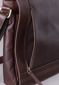 Brown leather shoulder bag with a textured finish, featuring a prominent zipper, solid stitching, and adjustable strap.
