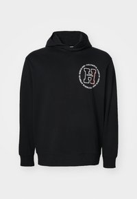 Czarna bluza z kapturem wykonana z bawełny, z przodu logo z białym i czerwonym napisem. Długi rękaw i ściągacze przy mankietach dopełniają design.