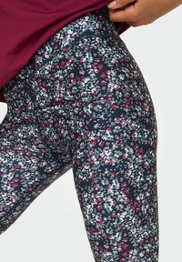 Blommiga leggings i marinblått, med ett litet flerfärgat blommönster i röd, vit och grå, hög midja och elastiskt tyg.