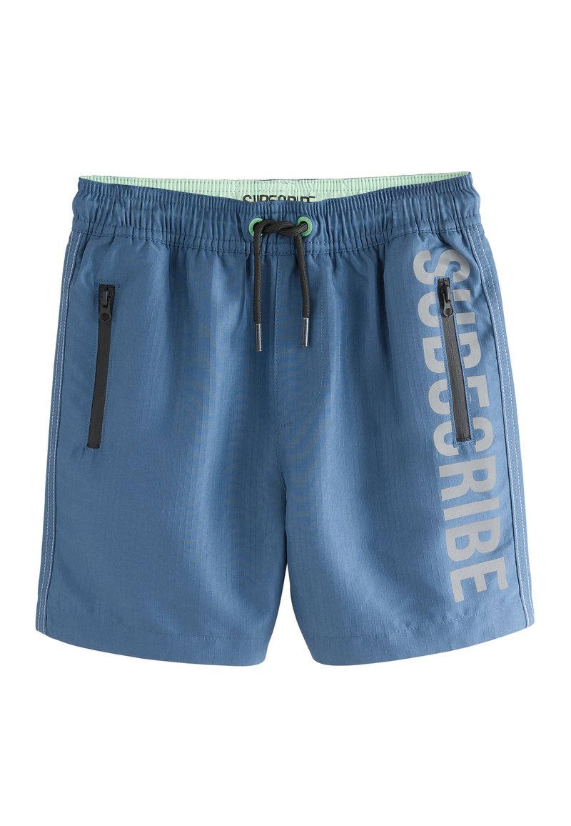 Pantaloncini da bagno blu con vita elastica, coulisse regolabile e due tasche laterali con cerniera. Caratterizzati da un testo verticale "SUBSCRIBE" in grigio chiaro.